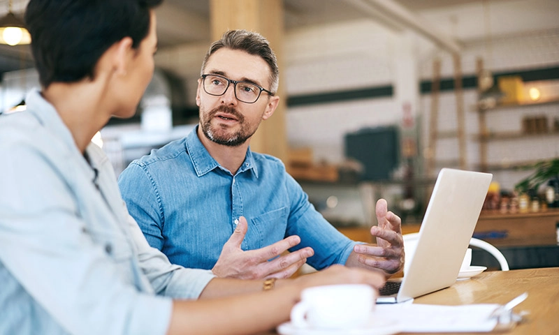 two colleagues having a casual meeting with a laptop